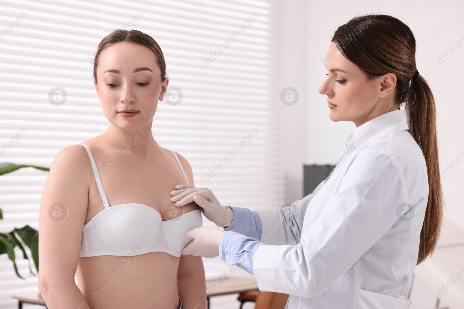 Photo of Mammologist checking young woman's breast in hospital