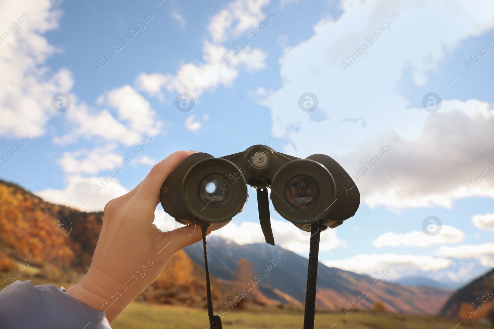 Photo of Boy holding binoculars in beautiful mountains, closeup