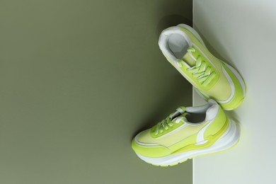 Photo of Stylish presentation of trendy sneakers on color background, above view. Space for text