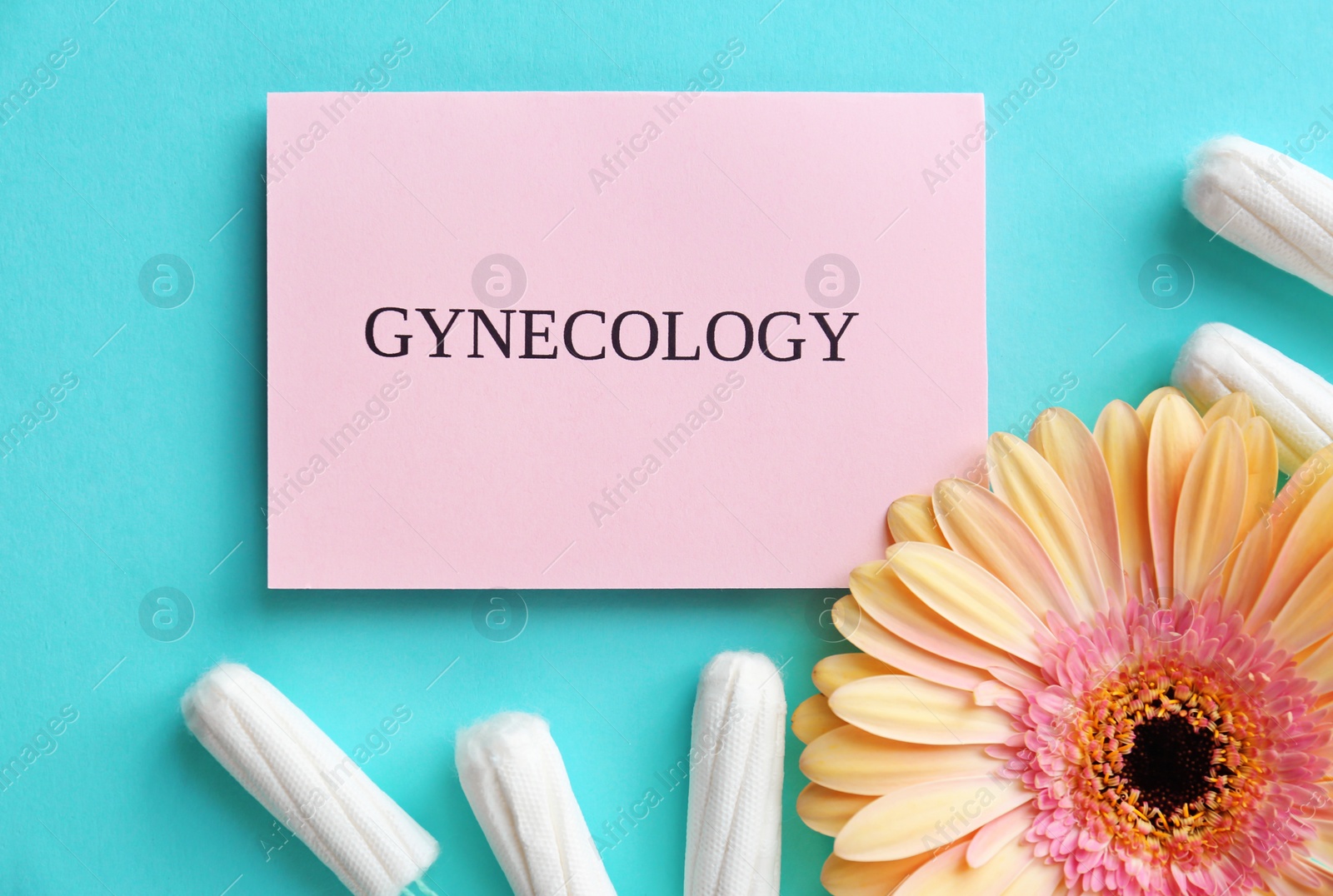 Photo of Card with word GYNECOLOGY, tampons and flower on color background, top view