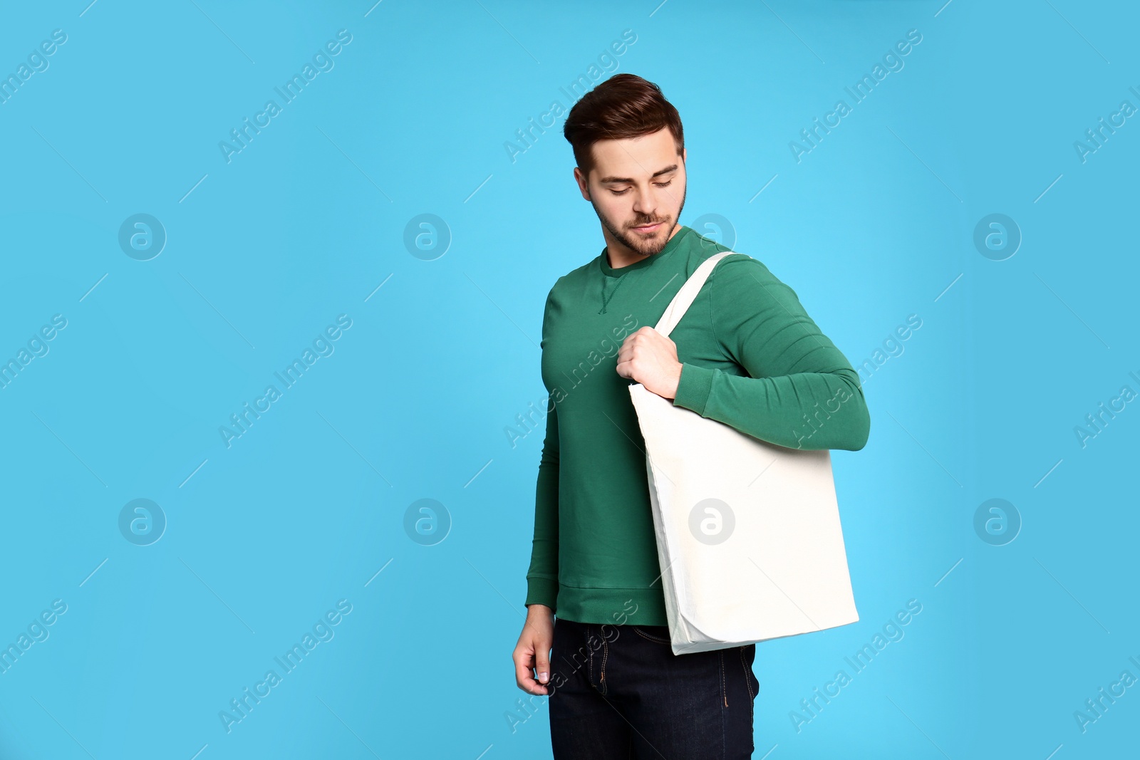 Photo of Portrait of young man with eco bag on blue background. Space for text