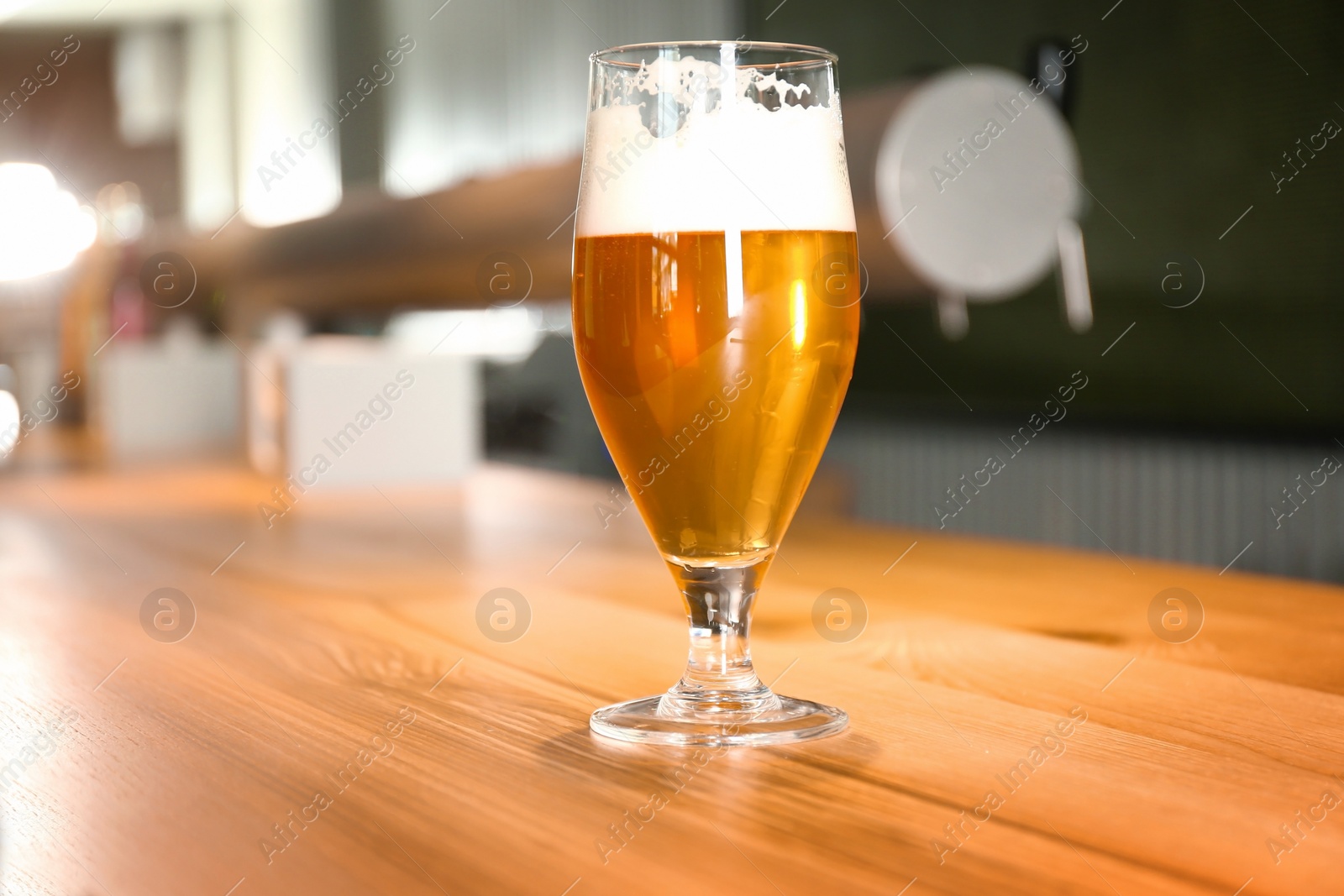 Photo of Glass of beer on wooden table in pub