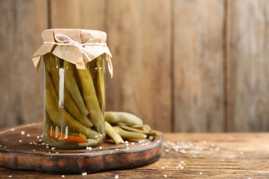 Canned green beans on wooden table. Space for text