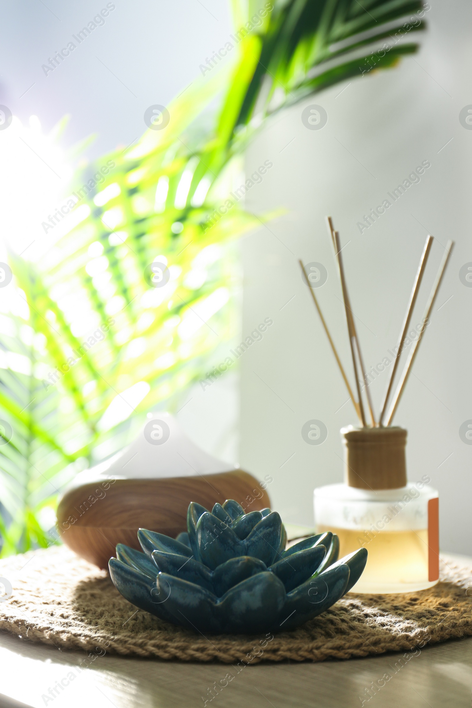 Photo of Aroma oil diffuser and reed air freshener on table in room