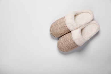 Photo of Pair of beautiful soft slippers on white background, top view. Space for text
