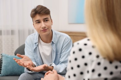 Psychologist working with teenage boy in office