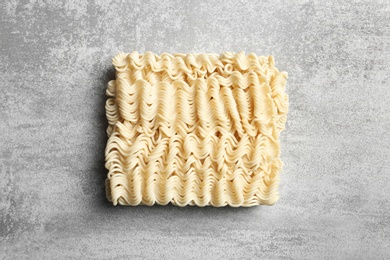 Photo of Block of quick cooking noodles on color background, top view