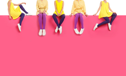 Women wearing different bright tights and stylish shoes sitting on color background, closeup 