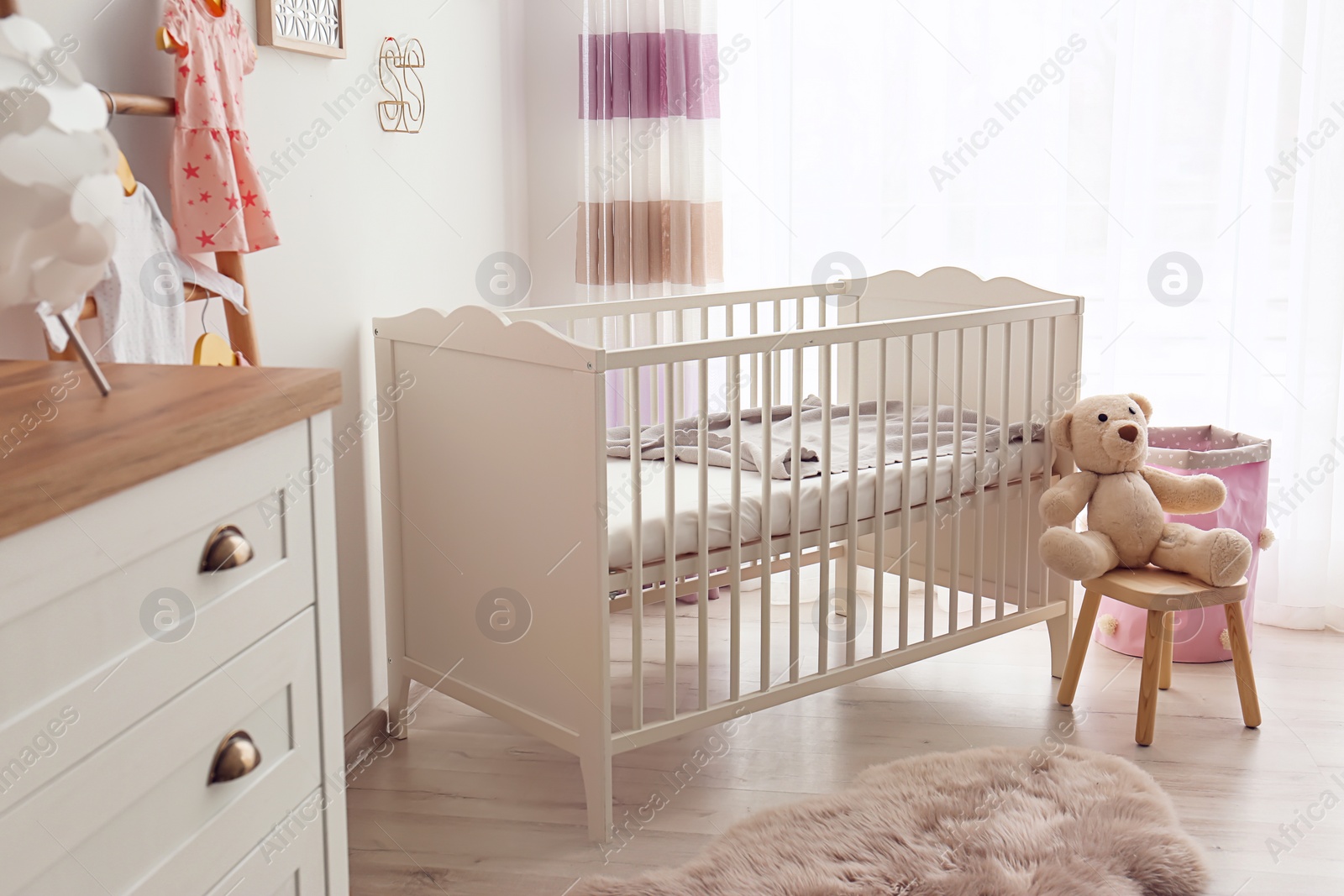 Photo of Cozy baby room interior with crib