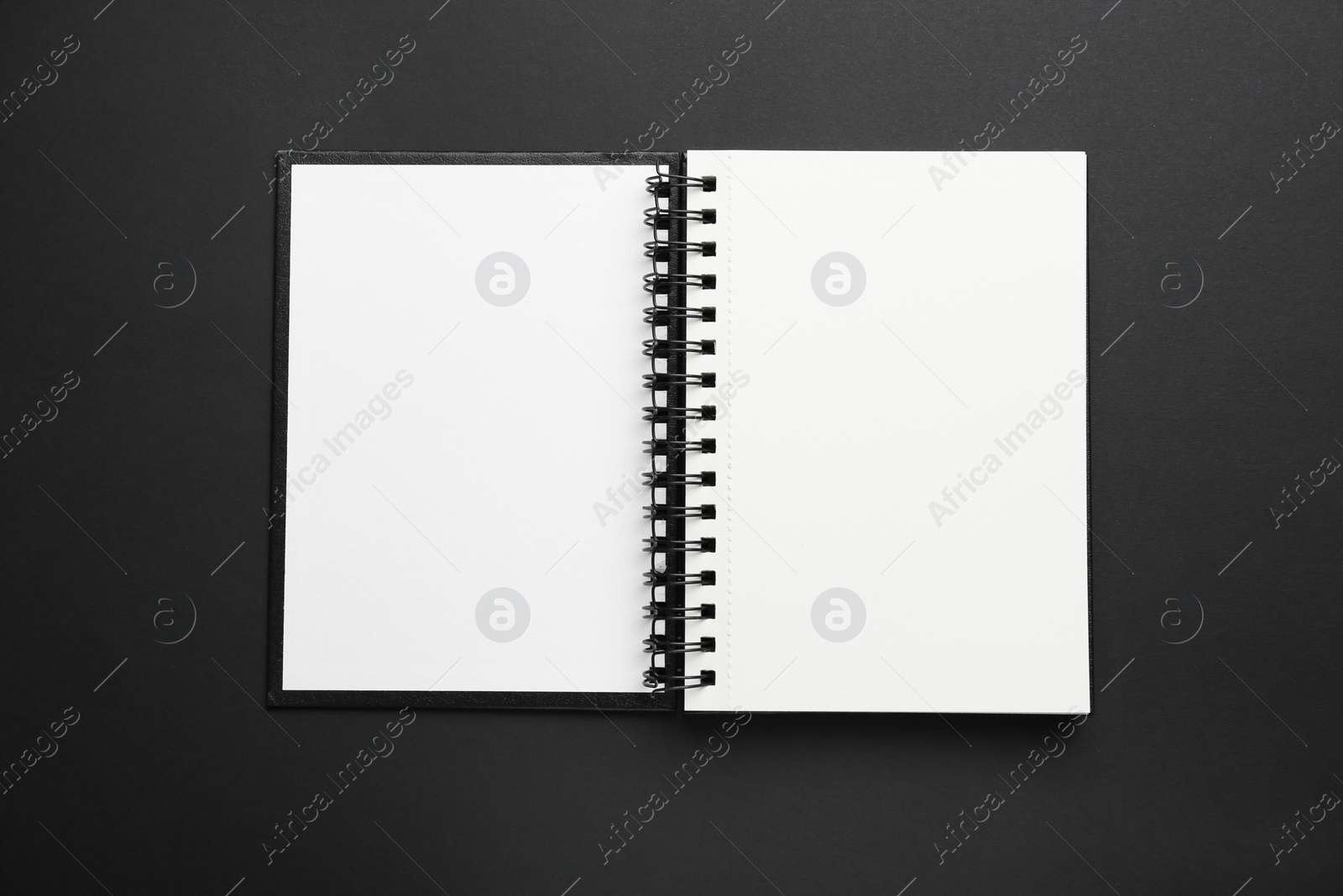 Photo of One notebook on black background, top view