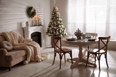 Photo of Festive table setting and beautiful Christmas decor in living room. Interior design