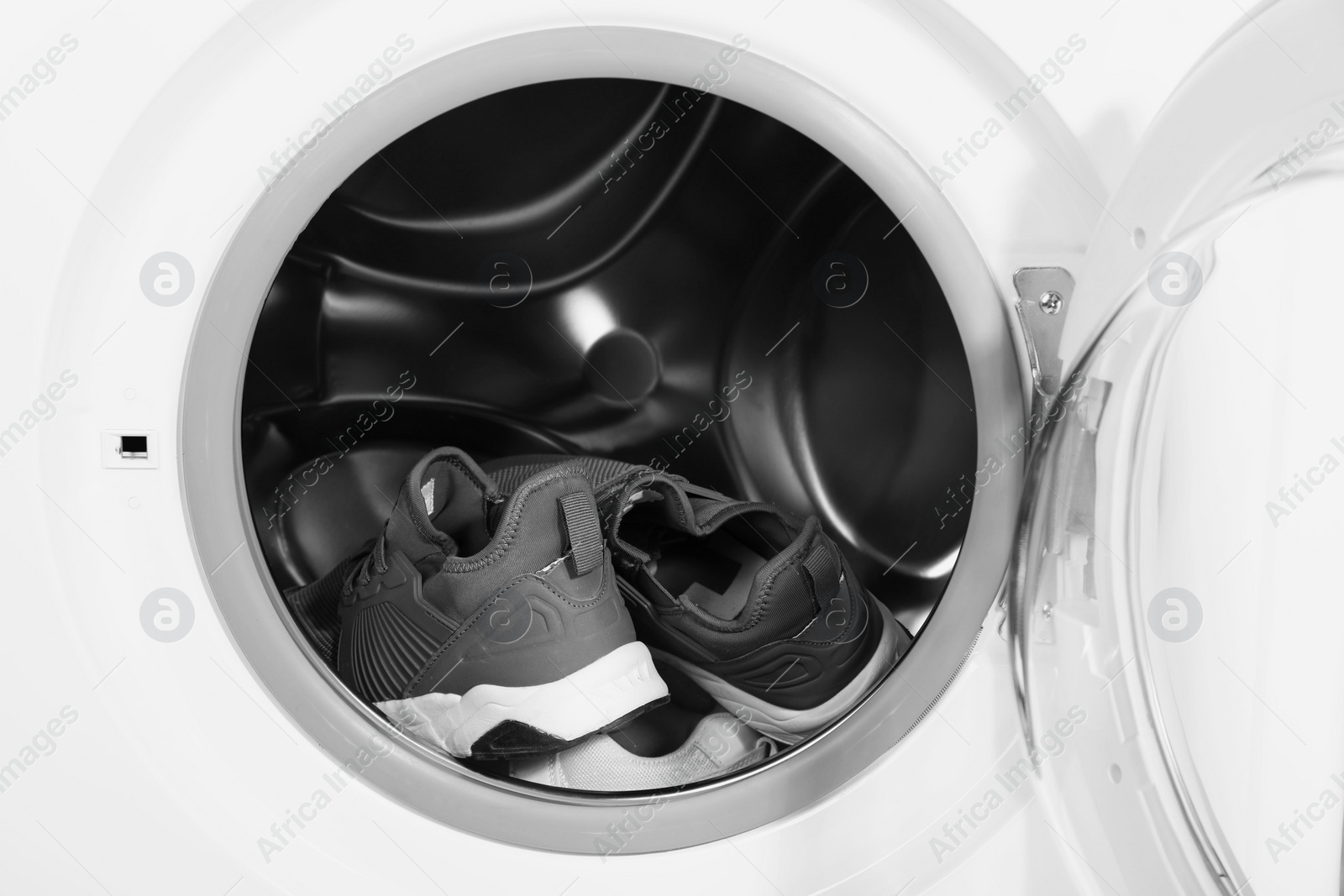 Photo of Stylish clean sneakers inside modern washing machine