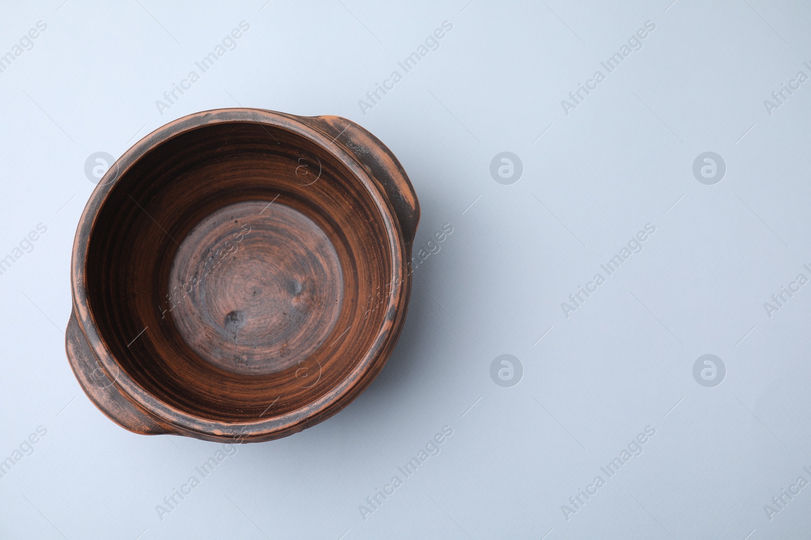 Photo of Ceramic bowl on white background, top view. Space for text