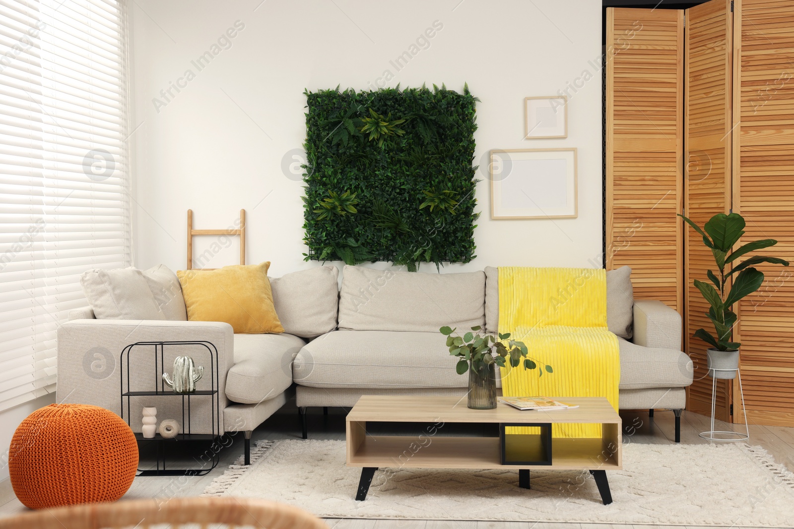 Photo of Green artificial plant wall panel and comfortable furniture in cozy living room. Interior design