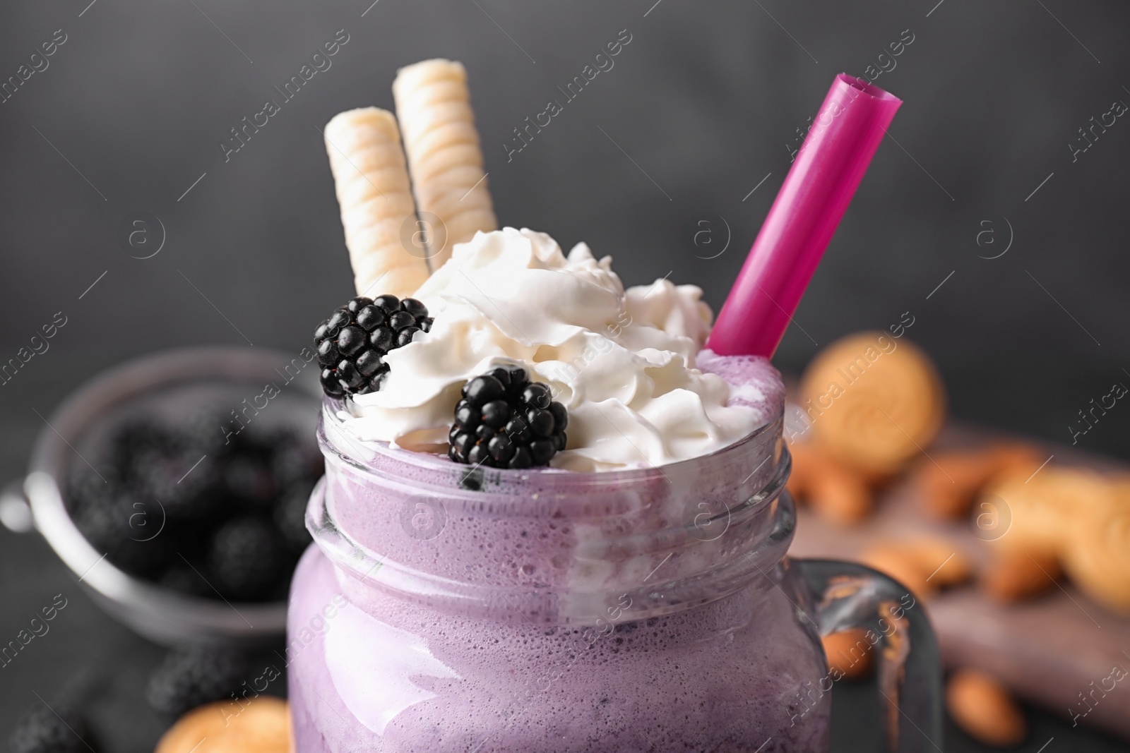Photo of Fresh tasty milk shake in mason jar on table, closeup