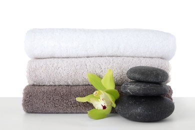 Photo of Fresh towels, spa stones and exotic flower isolated on white