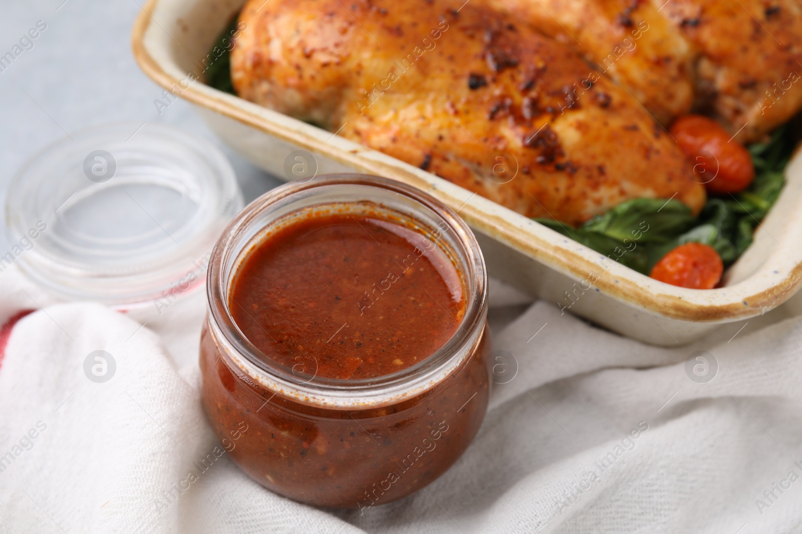 Photo of Baked chicken fillets with vegetables and marinade on table, closeup