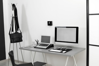 Modern workplace interior with computers on table. Space for text