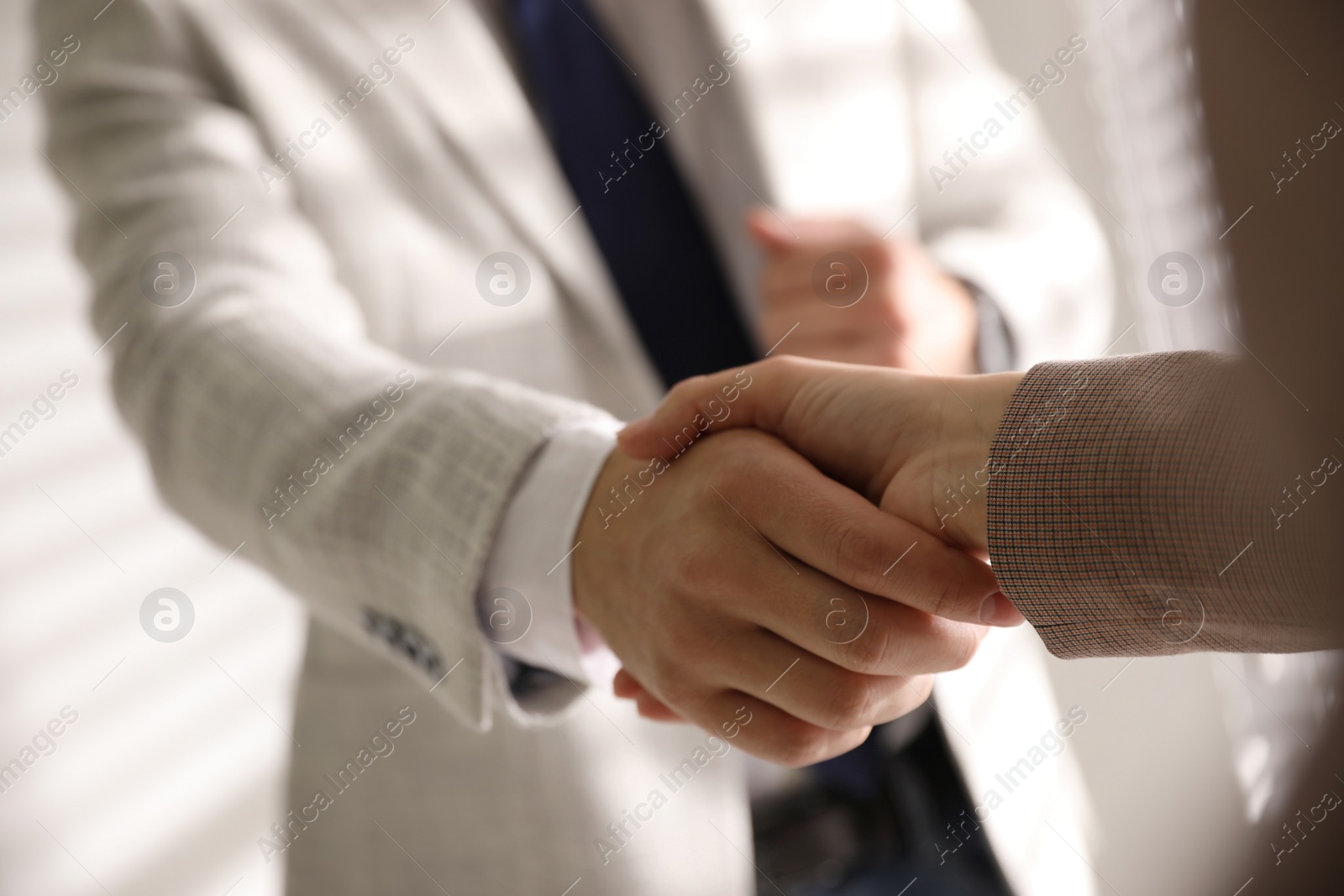 Photo of Business people shaking hands in office, closeup