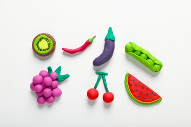 Photo of Different colorful fruits and vegetables made from plasticine on white background, top view