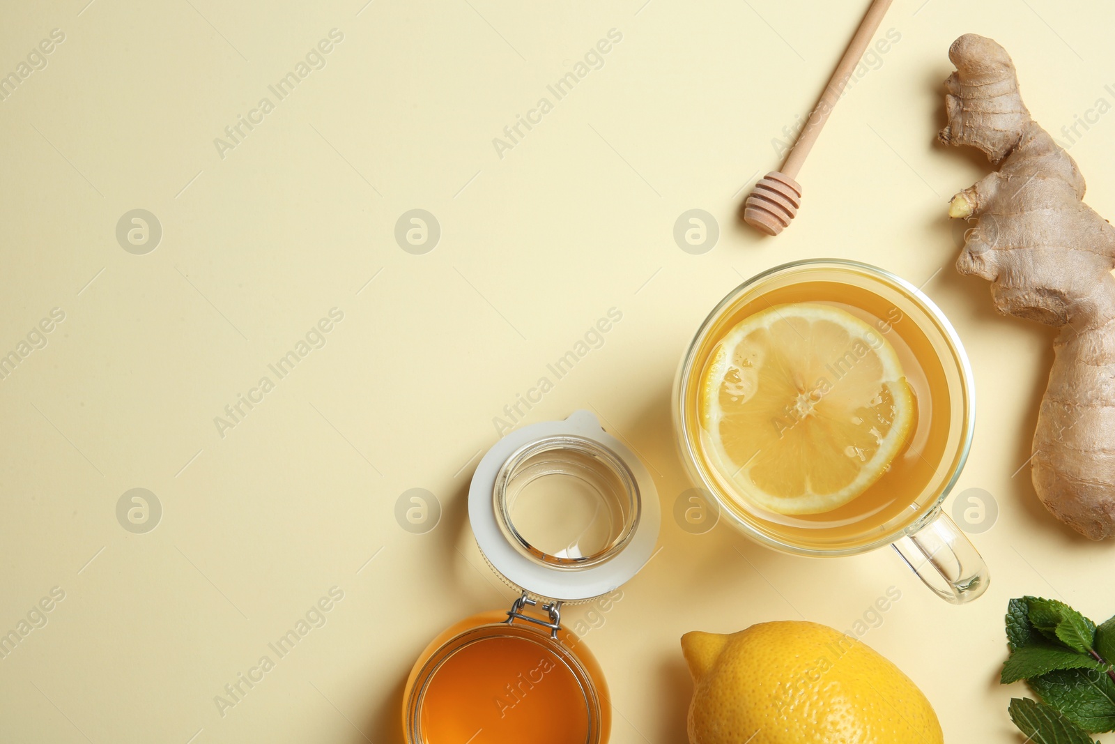 Photo of Flat lay composition with cup of lemon tea, ginger and honey on color background. Space for text