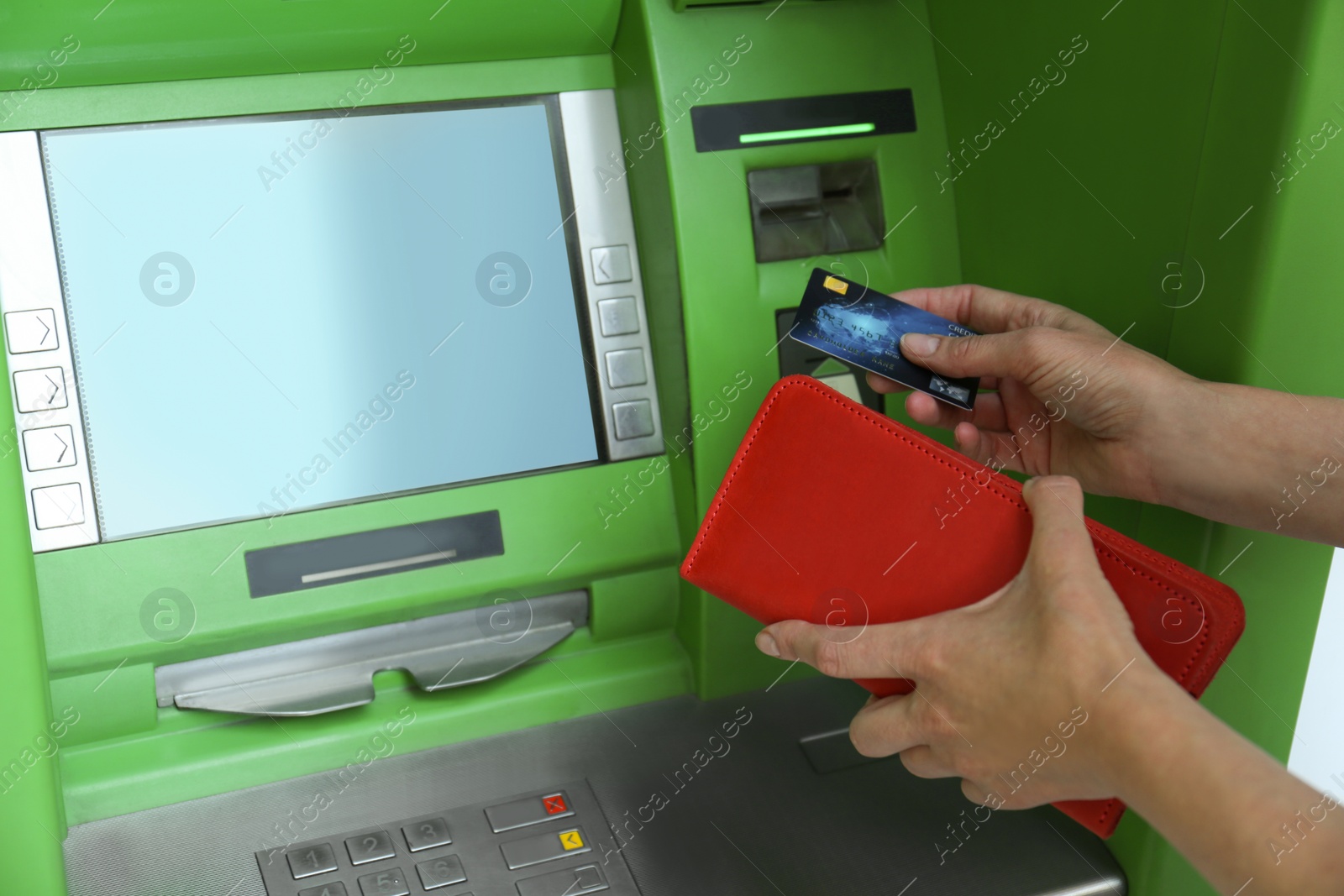 Photo of Mature woman with wallet and credit card at modern cash machine, closeup