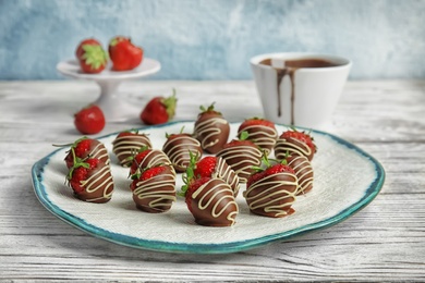 Photo of Plate with chocolate covered strawberries on table