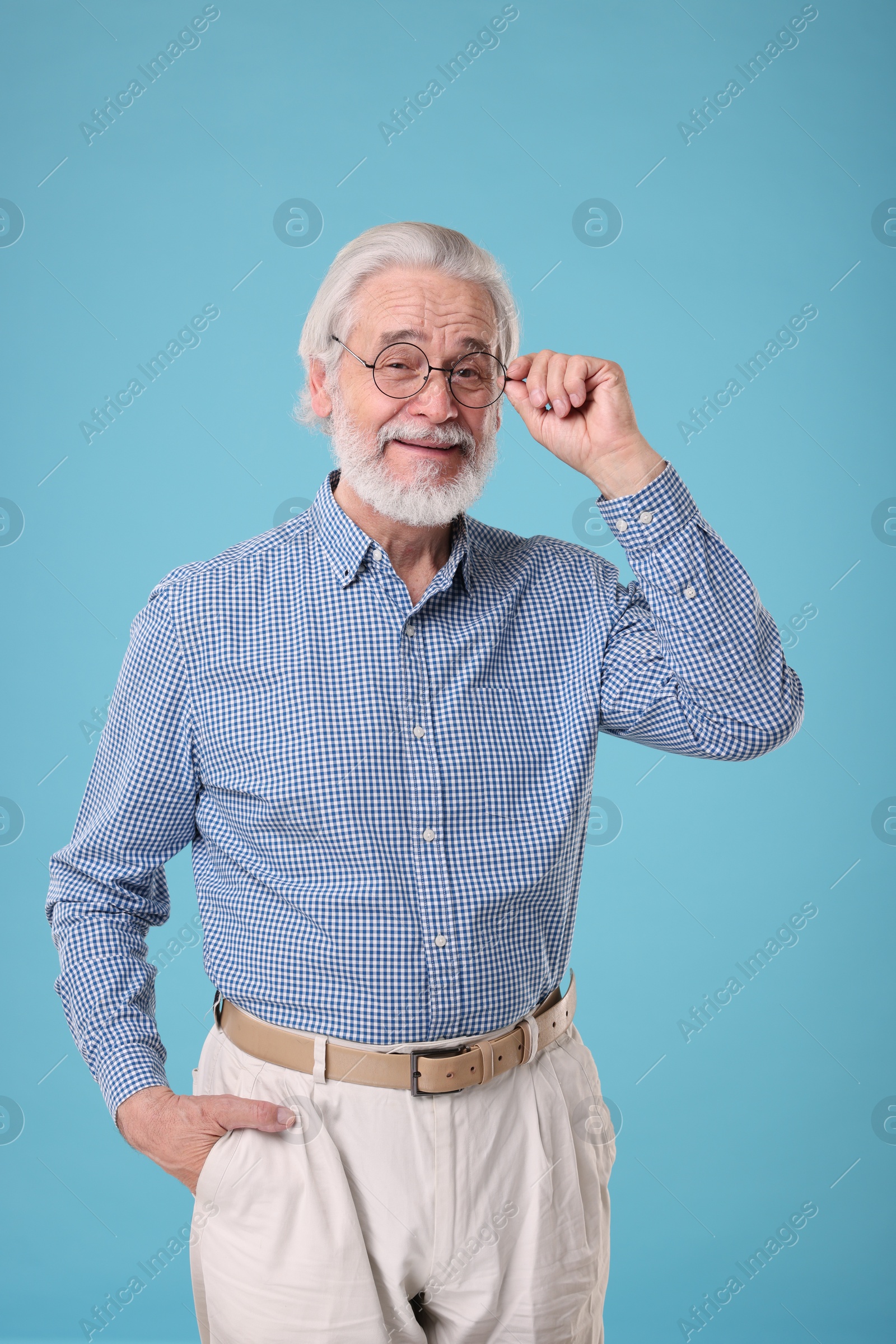 Photo of Portrait of stylish grandpa with glasses on light blue background