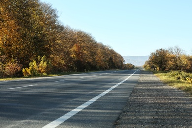 Asphalt road running through countryside on sunny day