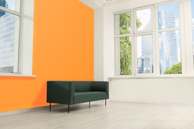 Beautiful interior with sofa near orange wall
