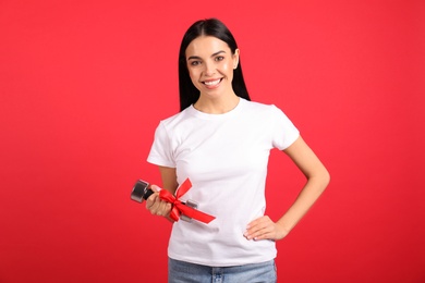 Photo of Woman with dumbbell as symbol of girl power on red background. 8 March concept