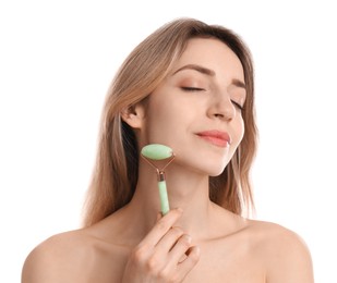 Young woman using natural jade face roller on white background