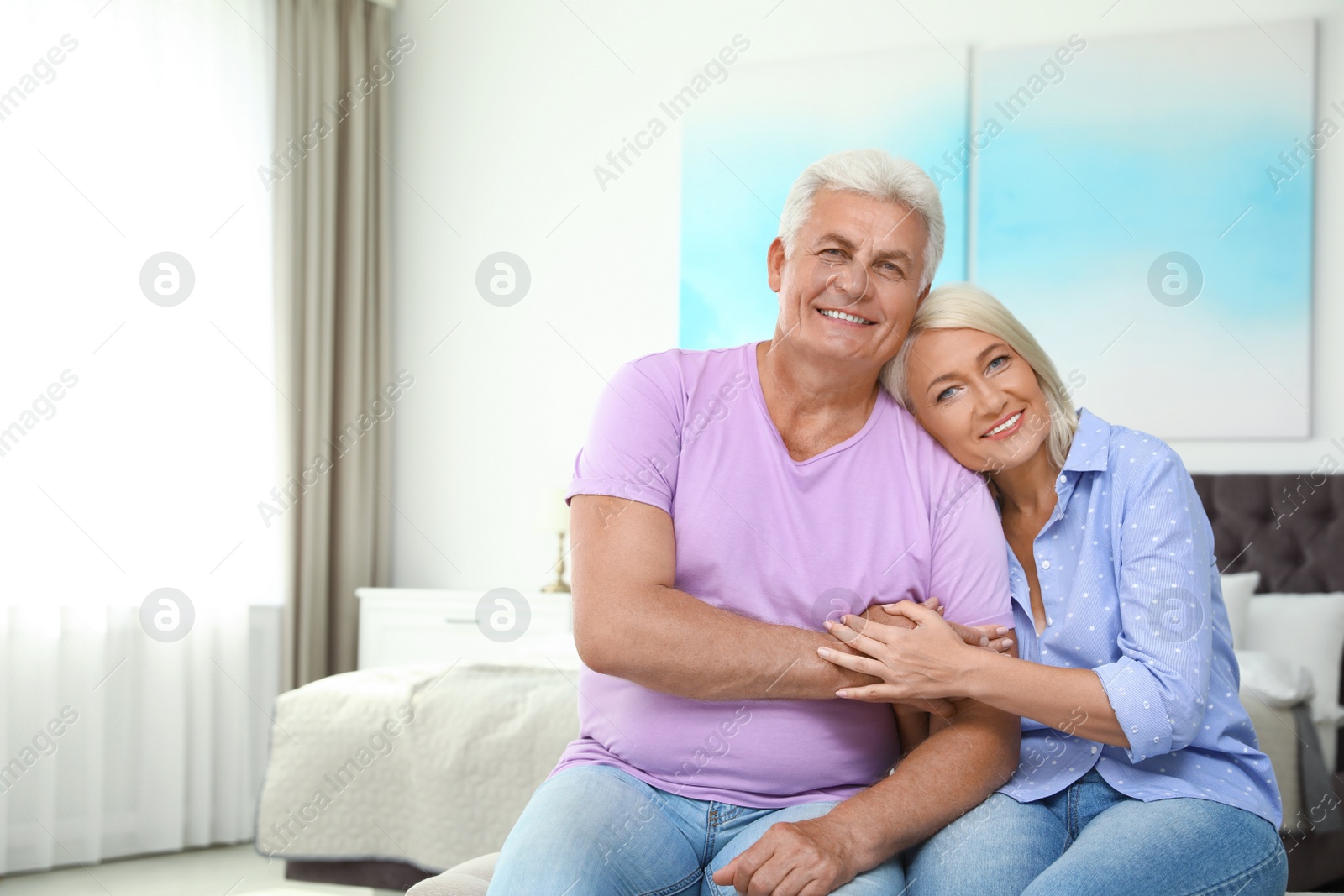 Photo of Portrait of happy senior couple at home. Space for text