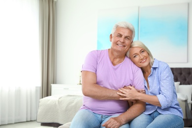 Photo of Portrait of happy senior couple at home. Space for text