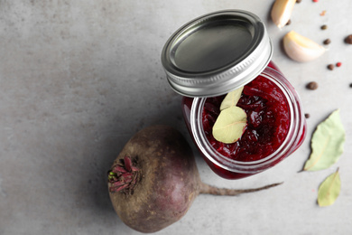 Pickled beets in glass jar on light table, flat lay. Space for text