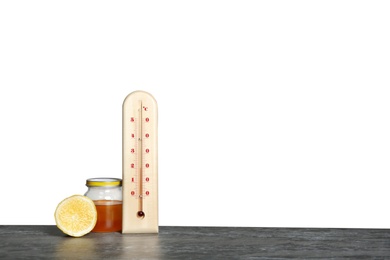 Photo of Thermometer, lemon and honey on table against gray background. Space for text