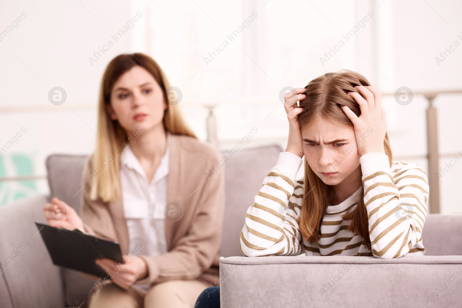 Photo of Young female psychologist working with teenage girl in office