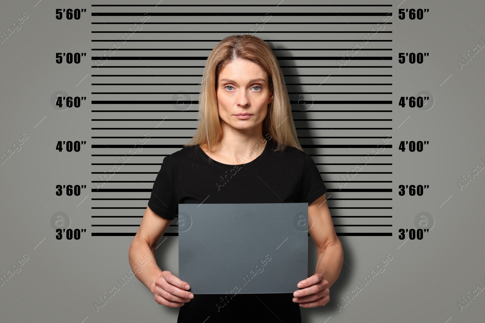 Image of Criminal mugshot. Arrested woman with blank card against height chart