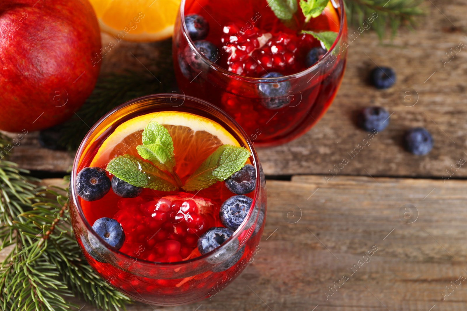 Photo of Aromatic Christmas Sangria drink in glasses on wooden table, above view