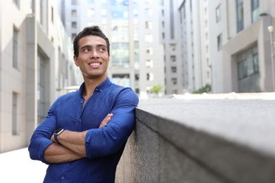 Photo of Handsome young African-American man on city street. Space for text