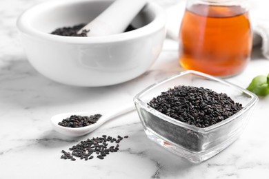 Photo of Black sesame seeds on white marble table