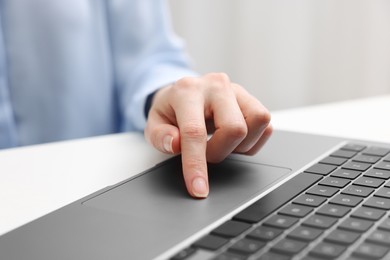 E-learning. Woman using laptop at white table indoors, closeup