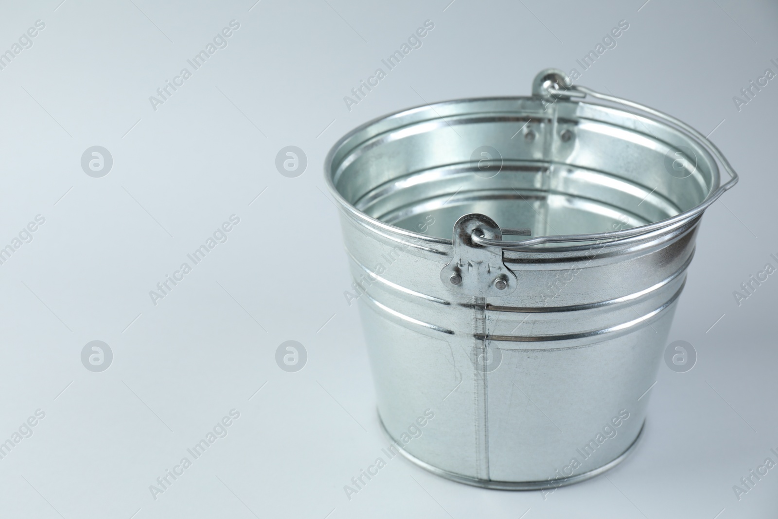 Photo of One shiny metal bucket on white background. Space for text