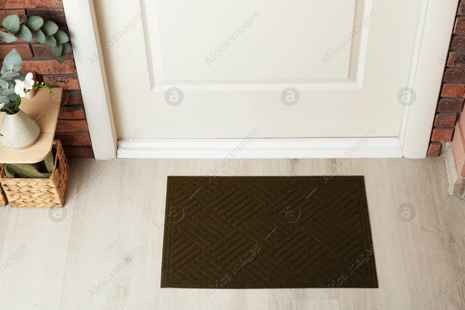 Photo of Dark olive door mat on wooden floor in hall, above view