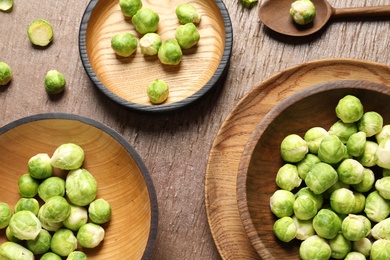 Photo of Flat lay composition with fresh Brussels sprouts on wooden table