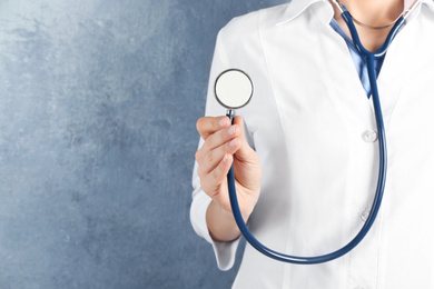 Photo of Doctor with stethoscope on blue background, closeup. Medical service