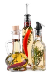 Photo of Different sorts of cooking oil with spices and herbs in bottles on white background