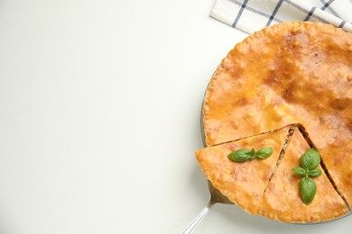 Photo of Delicious pie with meat and basil on white table, flat lay. Space for text