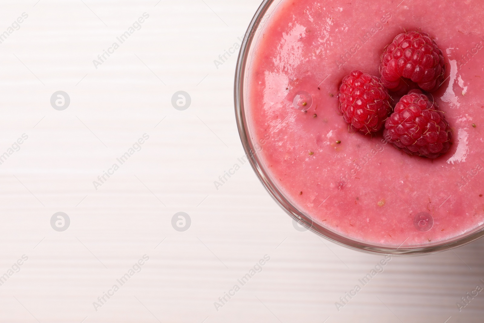 Photo of Delicious raspberry mousse on white wooden table, top view. Space for text
