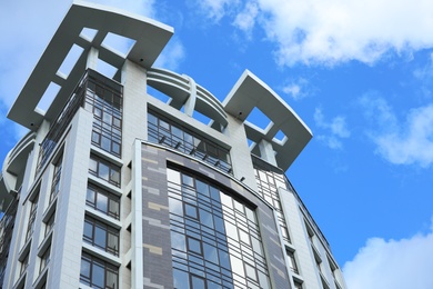 Photo of Low angle view of modern building against blue sky